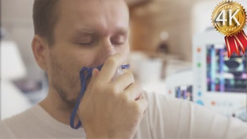 Un jeune homme respire à travers un nébuliseur