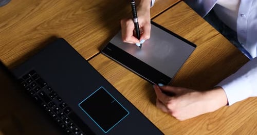 Illustrator hands scetching on tablet computer, using stylus