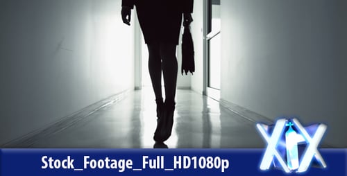 Woman Walks Down Dark Corporate Hallway