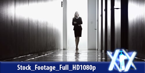 Woman Walking Down Hallway in Business Suit