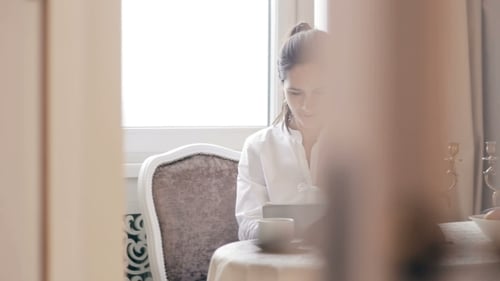Woman Using Tablet at Table Indoors