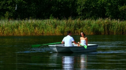 Couple in Rowboat on Lake in Summer