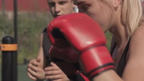 Woman Boxing with Fitness Trainer at Workout Facility