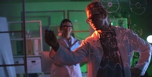 Scientists Writing Formulas on Glass Wall in Laboratory
