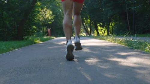 Slow Motion Legs of Man Running in Park in Summer