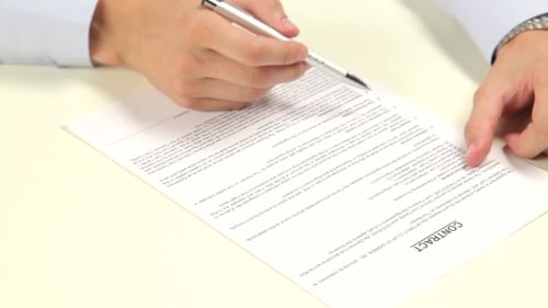 Signing Contract on Office Desk with Silver Pen