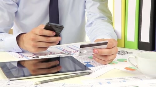 Young Adult Makes Payment with Phone and Card