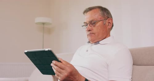 Man Using Tablet Device While Relaxing at Home