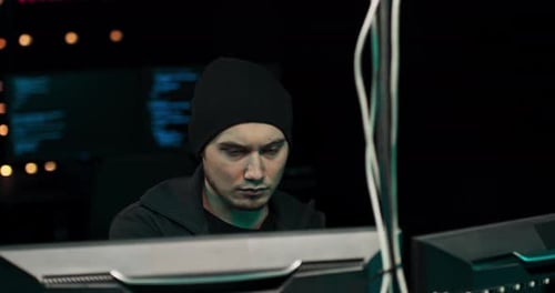 Focused Programmer Works at Computer in Dark Room