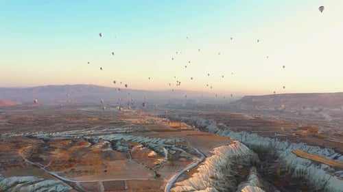 Hot Air Balloons Float Over Desert Landscape