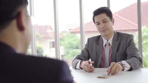 Businessman with Money at Negotiation in Modern Office