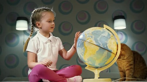 Girl Studies Globe with Cat Companion