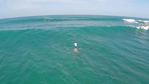 Aerial view of a man paddling while sup stand-up paddleboard surfing in Hawaii.