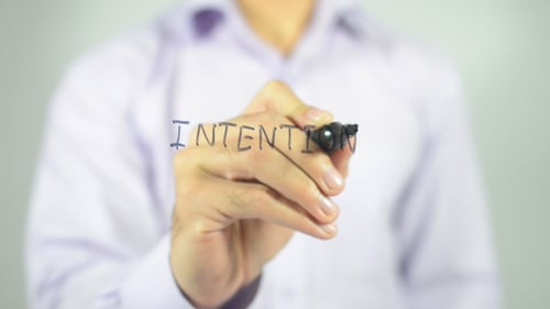 Hand Writes Intention on Clear Surface With Marker