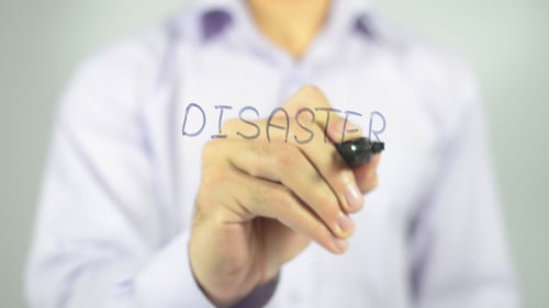 Hand Writes Disaster On Glass Surface