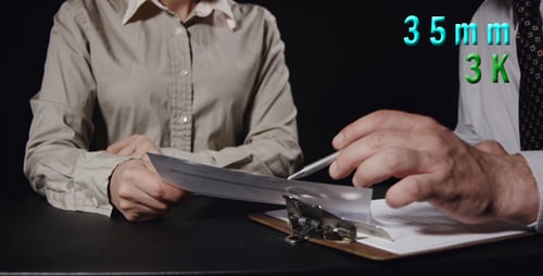 People Reviewing Paperwork in a Dark Workplace