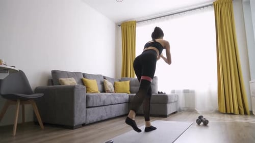 Woman Exercising with Resistance Band at Home