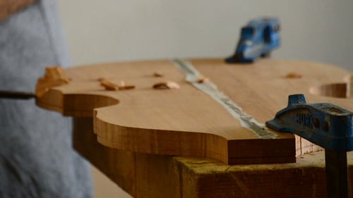 Luthier travaillant avec un ciseau dans un instrument
