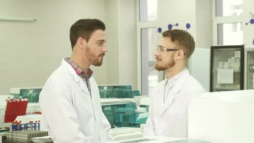 Scientists Talking in Bright Modern Medical Laboratory