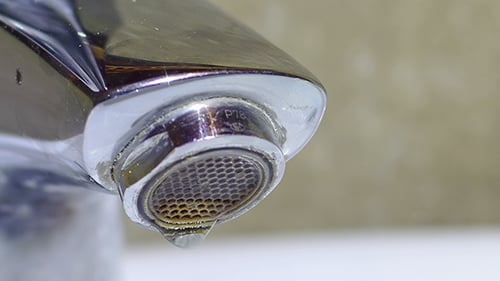 Close up of dripping chrome faucet