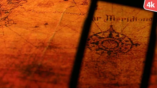 Magnifying Glass Inspecting Vintage Historical Map Close Up