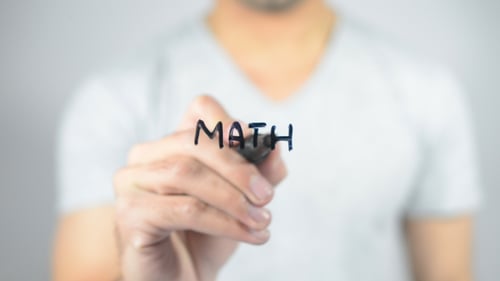 Man Writes the Word Math with Marker