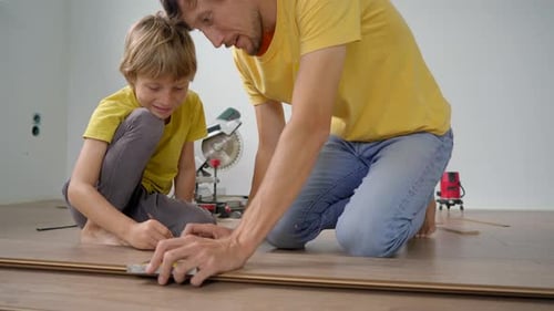 Father and Son Installing Laminate Flooring Together