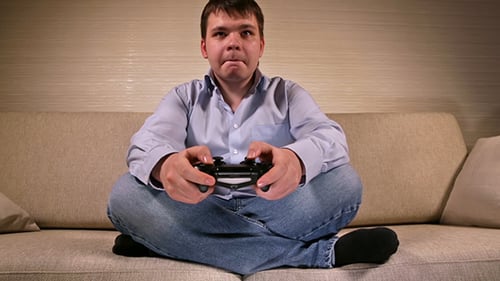 Young Adult Playing Video Game on Couch