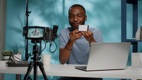 Man Recording Video at Desk with Laptop and Light
