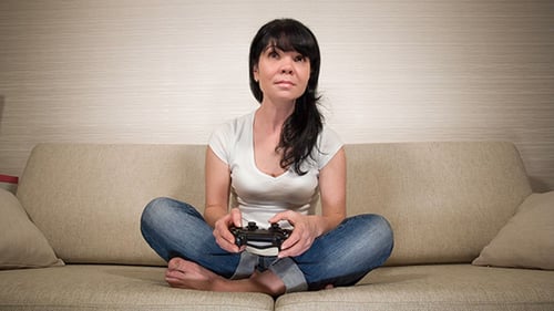 Woman Playing Video Game on Couch with Controller