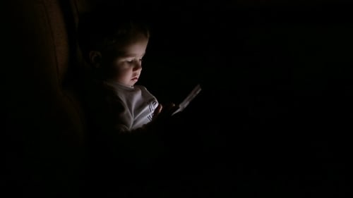 Infant Uses Tablet in the Dark