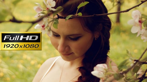 Heureuse femme enceinte dans le jardin fleuri