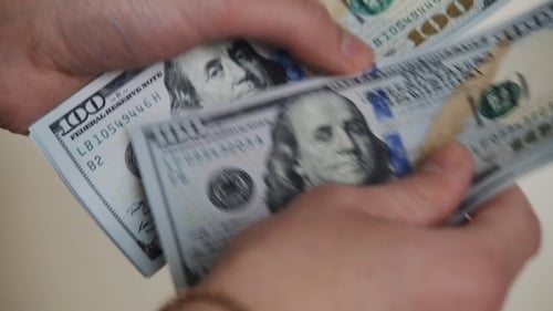 Close Up of Hands Counting Stack of Dollars