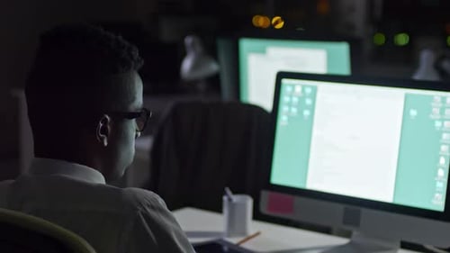 African Office Worker Sitting Alone in Office at Night