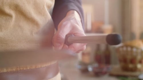 Sharpening a Kitchen Knife in Bright Kitchen