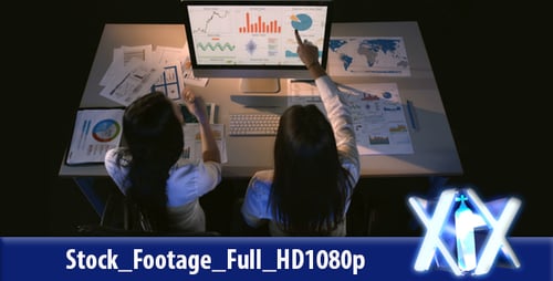 Two Women Analyze Data Together in Office Setting