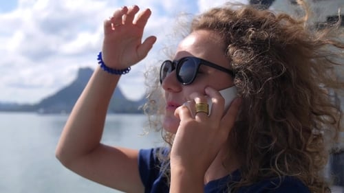 Young Woman Talking On Mobile Phone By The Sea