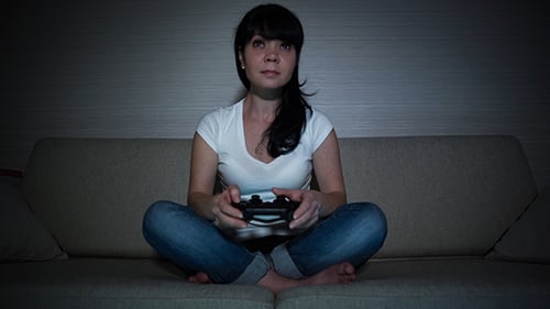 Woman Plays Video Game at Home on Couch