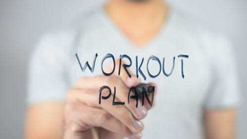 Hand Writes Workout Plan on Glass