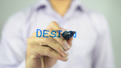 Hand Writes Design with Blue Marker on Glass