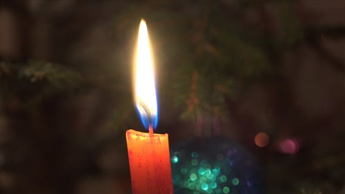 Burning Candle with Christmas Decorations