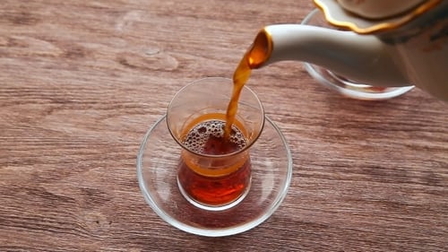 Pouring Tea into Traditional Glass Cup