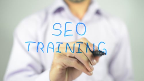 Hand Writes SEO Training Message Close Up