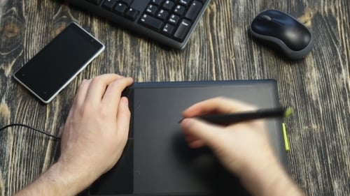 Adult Using Graphic Tablet On Desk Close Up