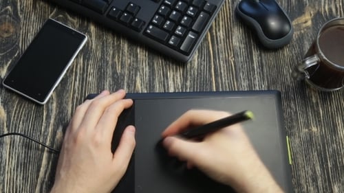 Man Using Stylus on Graphic Tablet Device