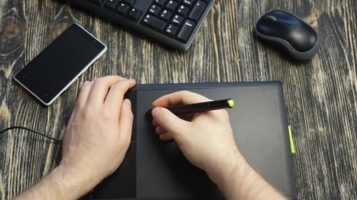 Man Drawing with Stylus on Graphics Tablet