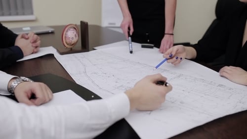 Adults Reviewing Blueprints in an Urban Office