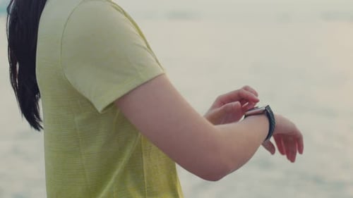 Woman Using Smart Watch near Body of Water