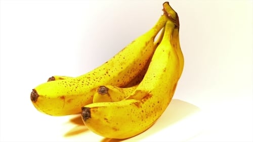 Ripe Yellow Bananas Rotating on White Background