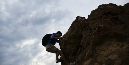 Man Climbing Rock Formation in Nature